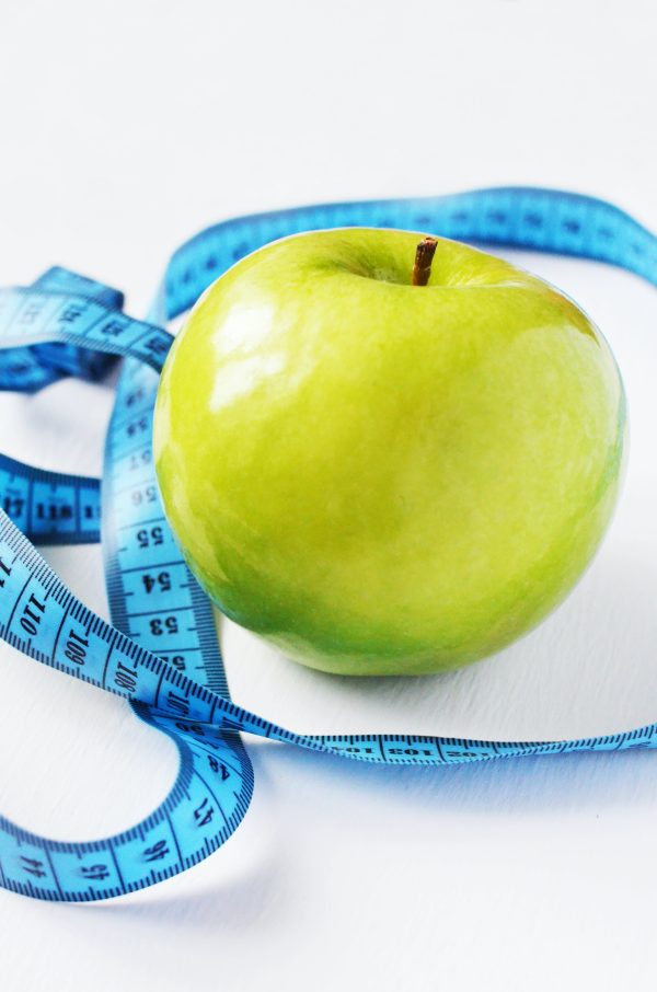 Manzana y cinta representando derivación a nutricionista